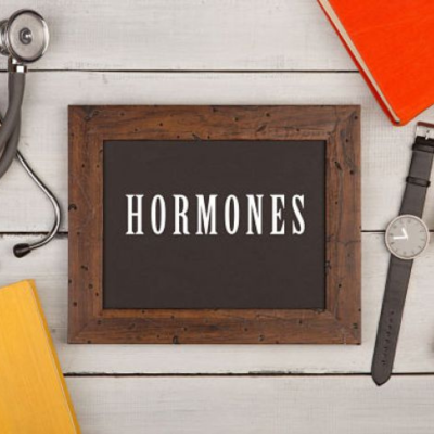 The image is of a sign on a wall with the word "HORMONES" written on it.