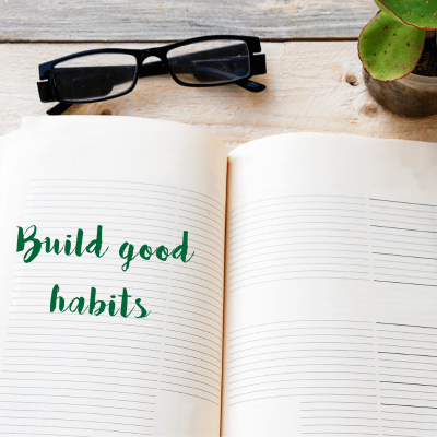 The image shows a pair of glasses next to a handwritten note with the text "Build good habits." It includes tags such as text, book, handwriting, glasses, and sunglasses.