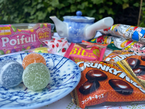 Image of sweets on a plate and other Japanese sweets in their packaging in the background