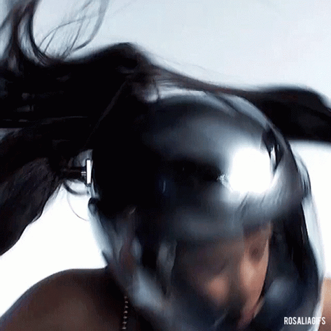 La cantante Rosalía con un casco de moto moviendo la cabeza
