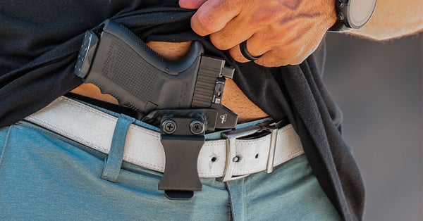 A person wearing an IWB Kydex holster for concealed carry