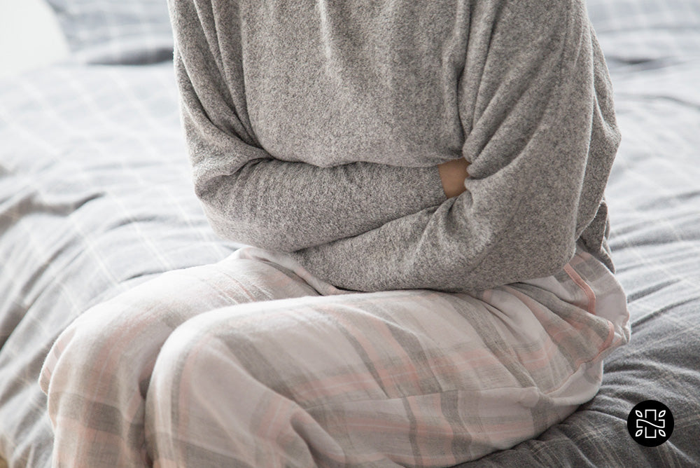 Woman holding herself in a stomach ache