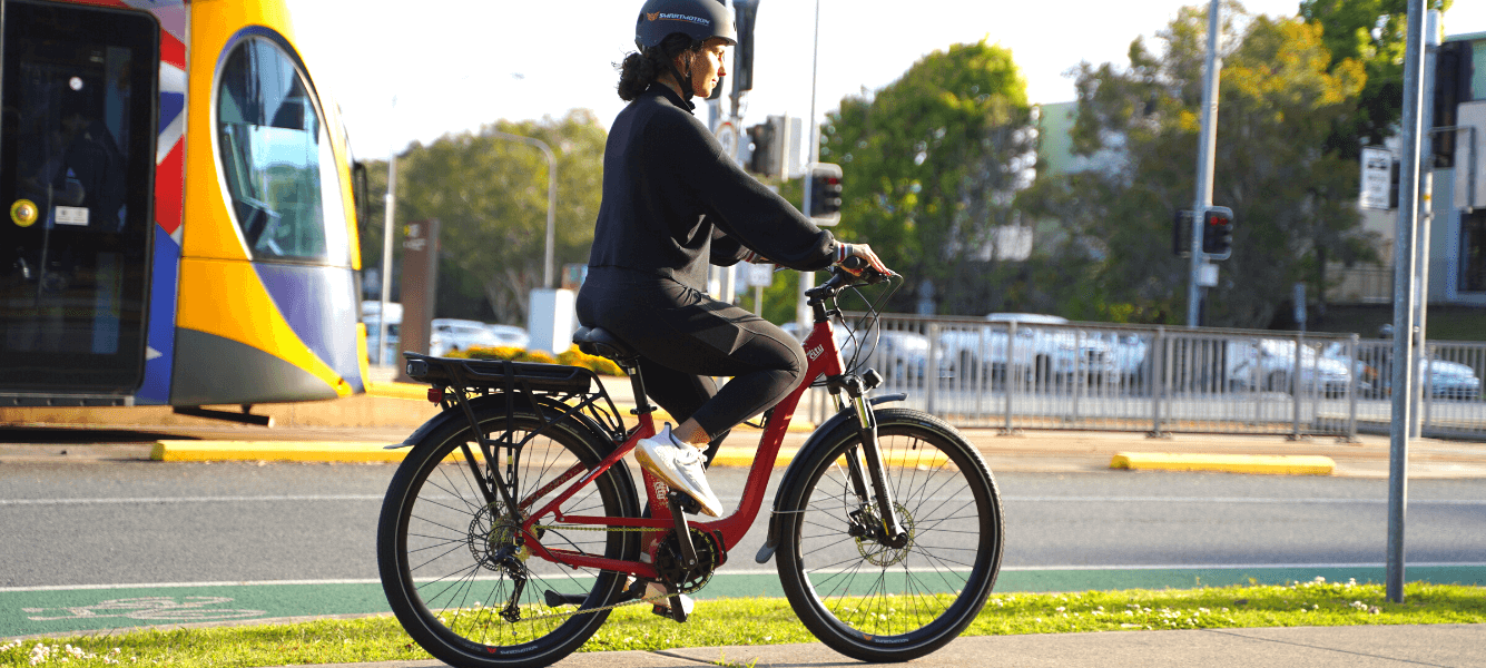 Midcity Red in town ridden by a girl next to gold coast tram