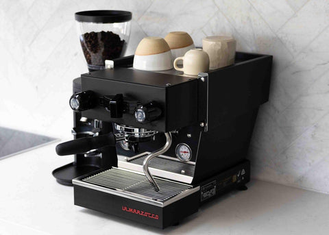 La Marzocco Linea Micra Black Oblique View with Cups on the top and a grinder next to it
