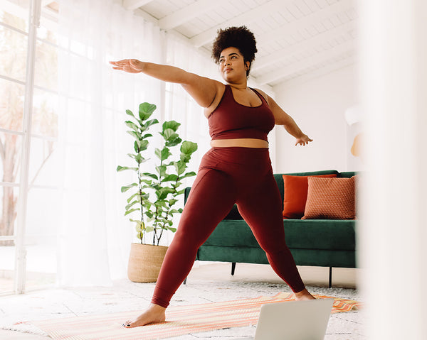 A woman stands in a yoga pose.