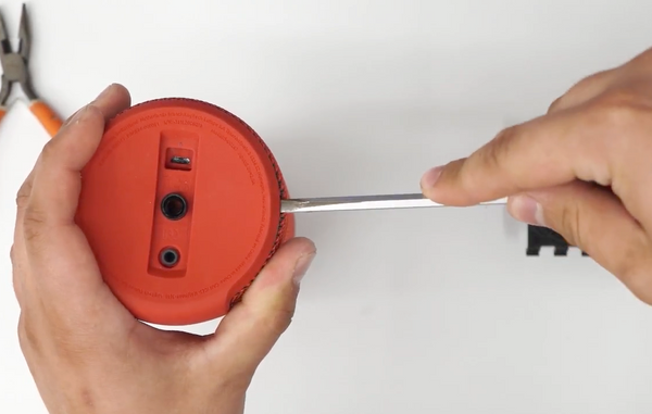 Inserting the screwdriver between the rubber and fabric