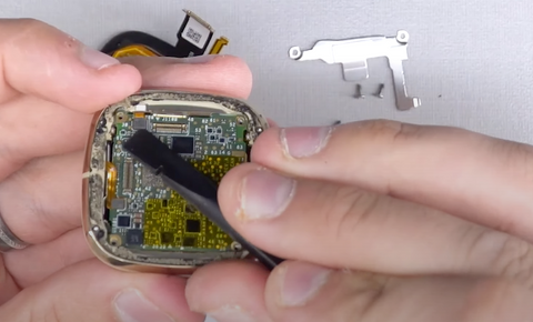 Disconnecting the battery connector ribbon from the motherboard on your Fitbit Sense