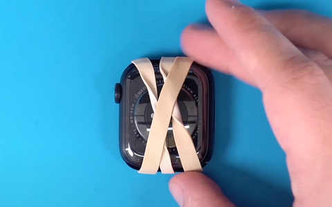 The back of the Series 7 Apple Watch with a rubber band wrapped around it after having a new back cover installed