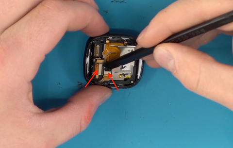 Disconnecting two ribbon cables from the mainboard of the Fitbit Versa 4 fitness tracker