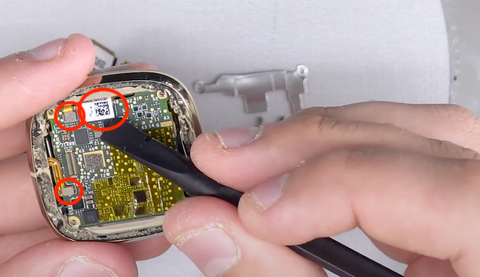 Lifting the 3 ribbon connectors from their spots on the Fitbit Sense motherboard