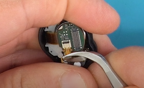 Using a pair of tweezers to pull the ribbon cable out of the socket on this Sony WF-1000XM4 earbud