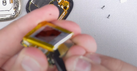 Lifting the battery away from the Fitbit Sense motherboard