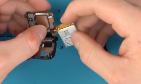 Clipping the new battery ribbon into its place on the Fitbit Versa 4 motherboard