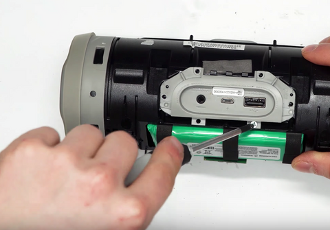 Removing the two screws that hold the charge port assembly in place