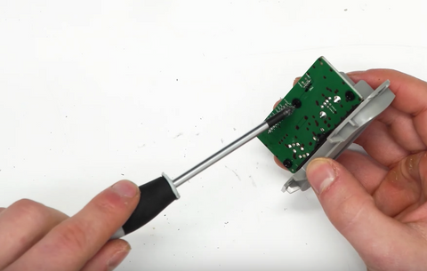 Removing the 3 screws that hold the circuit board into its housing. 