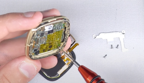 Installing one screw back into the Fitbit Versa 3 motherboard