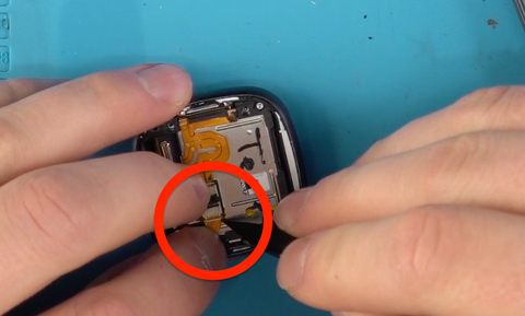 Using the pointed end of your spudger to slide the small ribbon cable into its connector on the Versa 4
