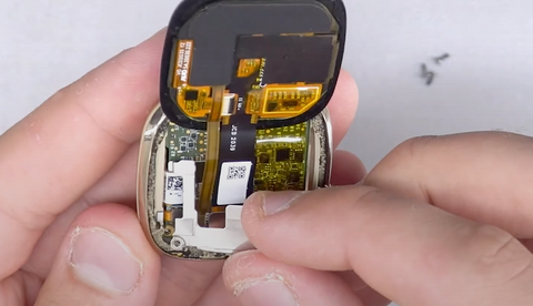 Positioning the metal shield over the Fitbit Sense screen connectors 