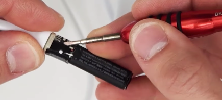 Removing the power button rubber piece with a flat screwdriver