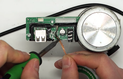 Removing excess solder with solder wick and flux