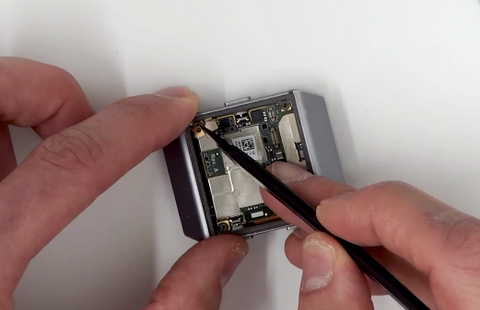 Placing the metal bracket over the battery ribbon plug