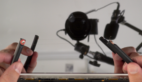Using a metal wire between two handles to remove a metal bracket from the old LCD Panel on the A2338 MacBook Pro