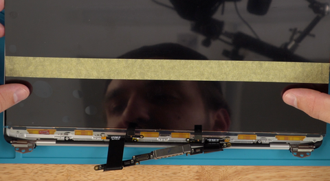 Line up the new A2338 screen with the screw holes and rubber gasket then lay it down onto the new adhesive that you applied