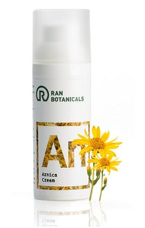 קרם ארניקה של Ran Botanicals במיכל לבן, עם פרחים צהובים בצד, מתאים לעיסוי עור ושרירים, להקל על כאבים ופציעות ספורט.