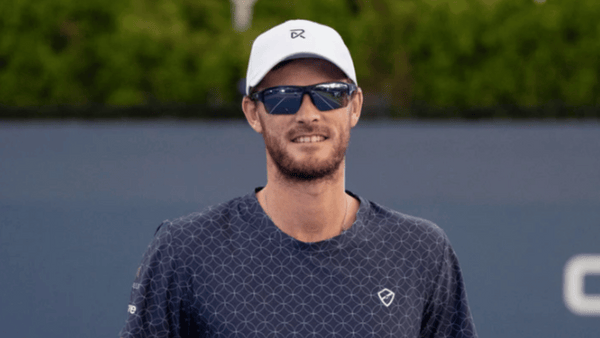 Jamie Murray wears a pair of RIA Eyewear sunglasses on a tennis court.