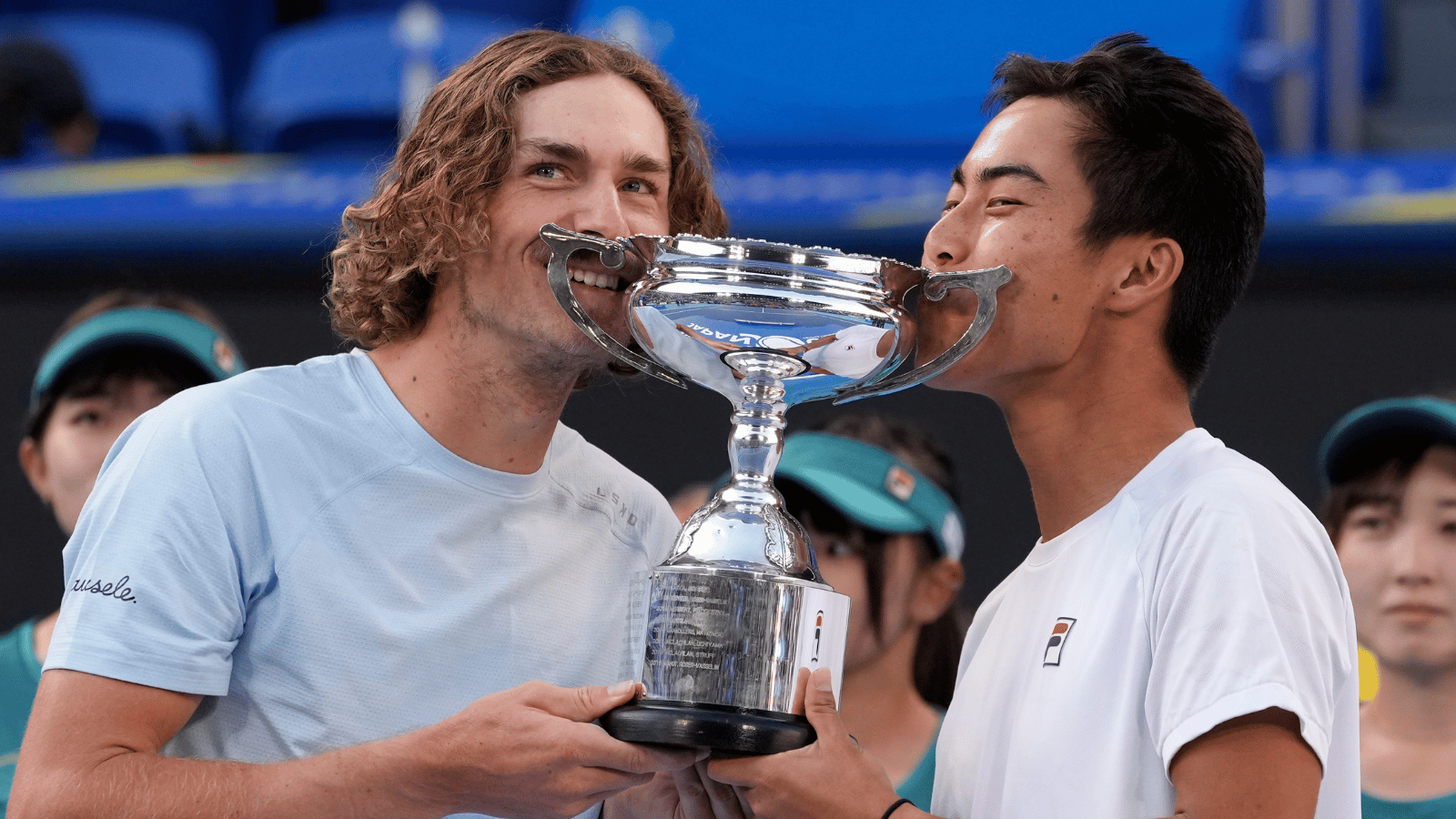 Two men kiss the Australian Open doubles trophy in 2023.