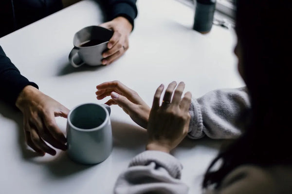 A couple sitting at a table with coffee mugs, discussing how does ED affect women.