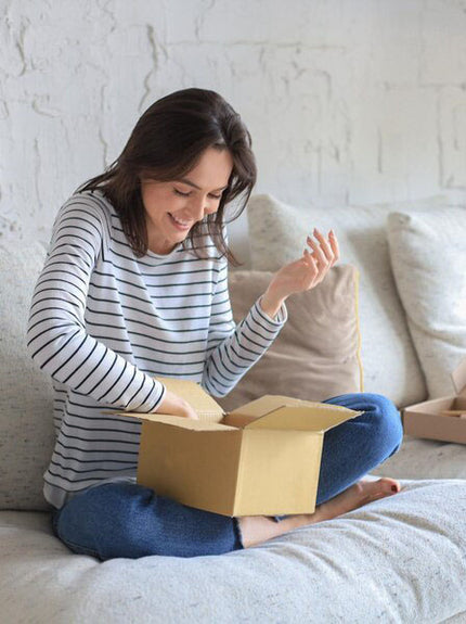 pretty-woman-is-unpacking-parcel-expressing-joy-sitting-sofa-home.jpg__PID:ed8978bd-31b9-4bef-b515-2ccc969f8f87