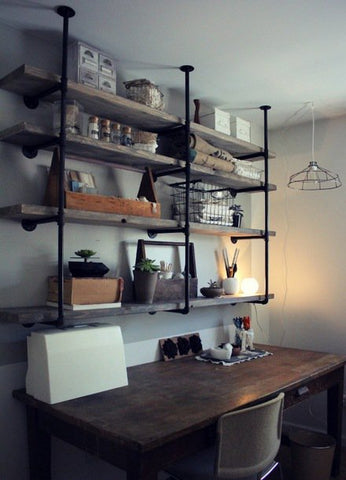 Une étagère industrielle avec des livres et des accessoires minimalistes