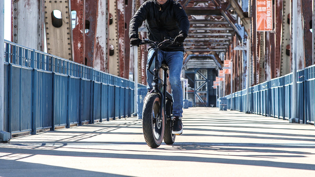 Man riding Emerald Ebike across a bridge