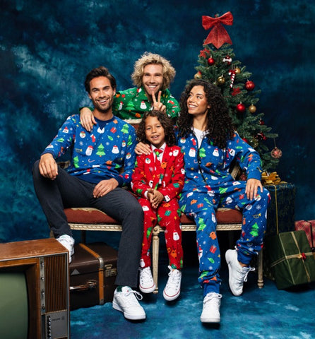 Group of people wearing Christmas outfits in front of Christmas tree