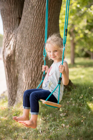 little girl on classic wooden swing