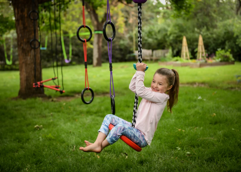 little girl on slackers climbing rope swing 