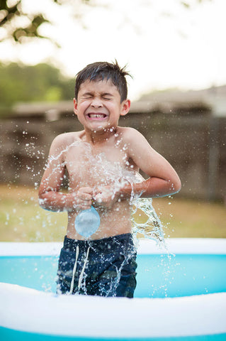 boy playing with water balloons