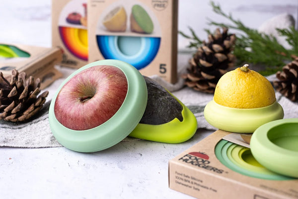 Eco friendly silicone food and avocado huggers on festive background