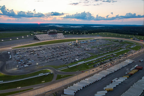 Aerial image of Nashville Superspeedway at sunset during Import Alliance Summer Meet 2023. More than 1,000 vehicles are shown filling the infield at the racetrack at sunset.