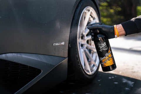 Action shot of Citrus Power being sprayed onto the surface of a Lamborghini Huracan during a wash. Image frames the full bottle mid-spray.