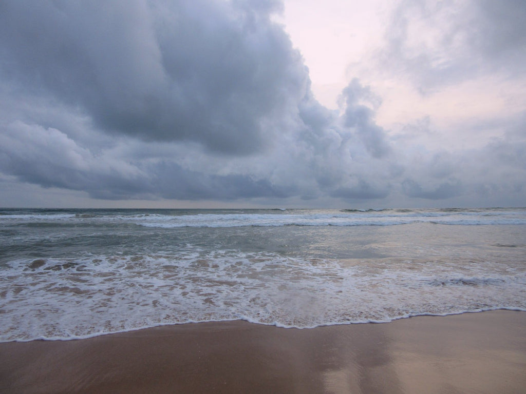 Bentota beach, Sri Lanka, at early evening with clouds and pale pink sky.