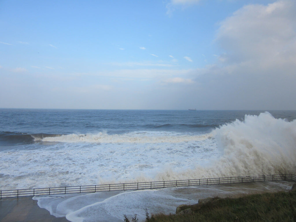 Waves crashing against promenade barrier in Whitley Bay, England