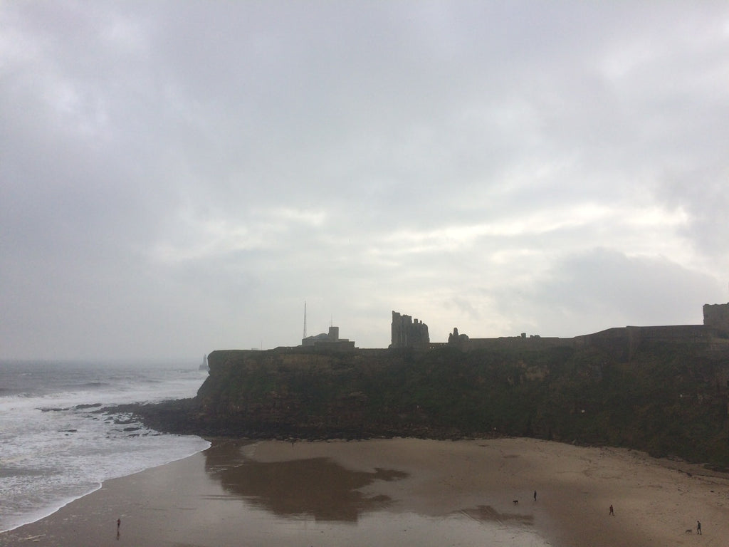 Silhouette of the Priory seen from Tynemouth Beach on a grey, damp day.