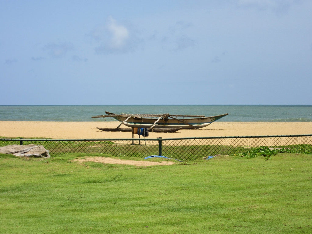 Negombo beach with boat on sand.