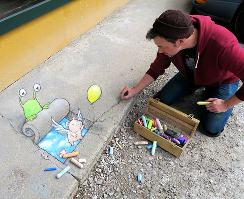 David Zinn drawing 3D hole illusion on sidewalk