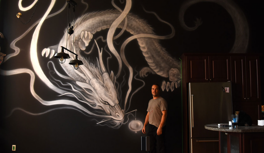 artiste qui a peint un dragon sur un mur