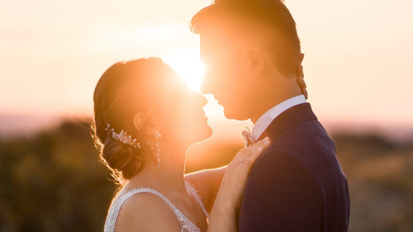 Mariés face à face avec un rayon de soleil qui dessine leur silouhette