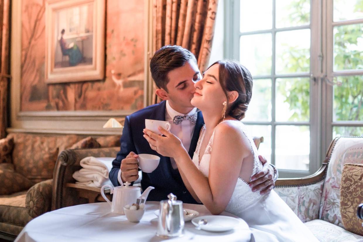 Mariés qui boivent dans des tasses à thé dans un salon au décor prestigieux 