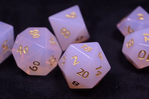 Pink opalite precious stone dice set on a black background